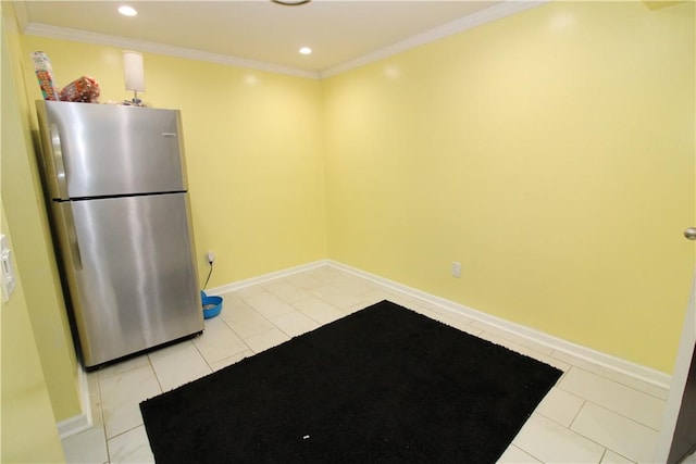 kitchen with freestanding refrigerator, light tile patterned flooring, crown molding, baseboards, and tile counters