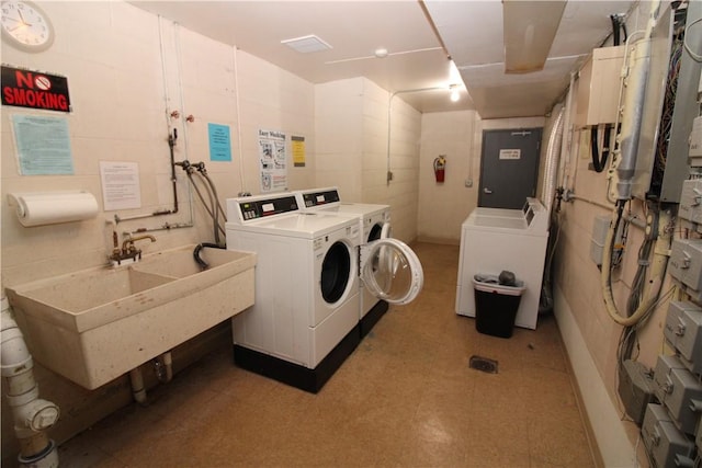 community laundry room with a sink and washer and clothes dryer