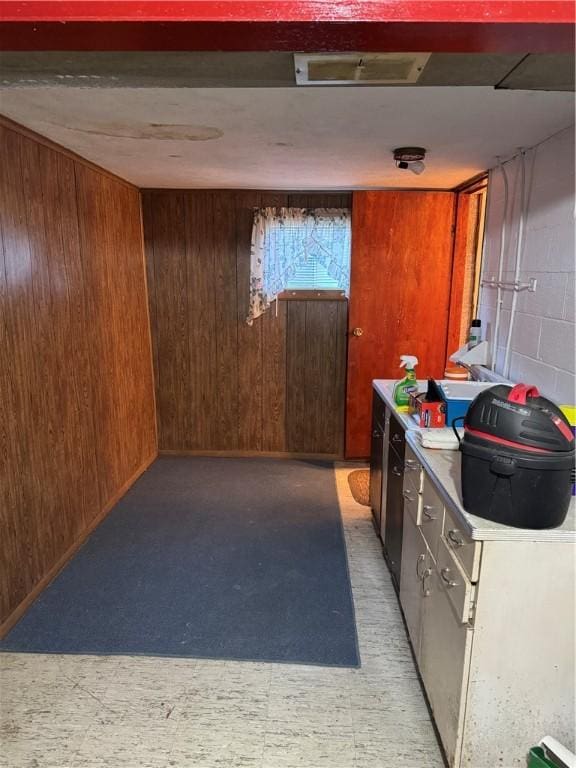 bar with concrete block wall, light floors, and wooden walls