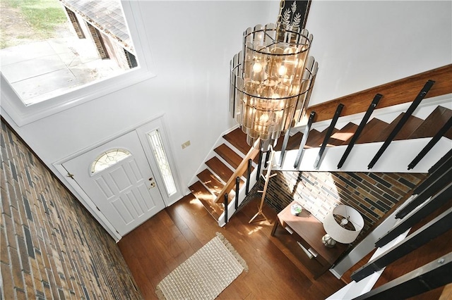 entryway featuring stairway, a notable chandelier, and wood finished floors