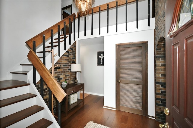 stairs featuring a high ceiling, baseboards, wood-type flooring, and a chandelier