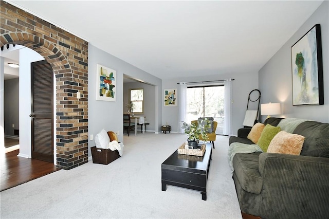 living area featuring arched walkways and carpet flooring