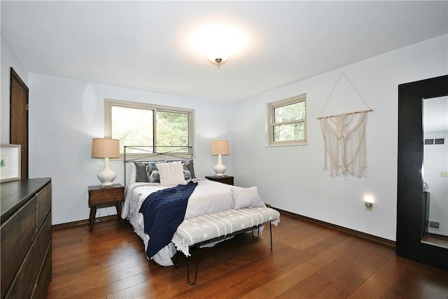 bedroom featuring visible vents, baseboards, and dark wood-style flooring