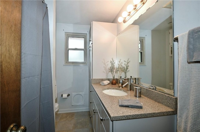 bathroom with vanity, toilet, a shower with curtain, and baseboards