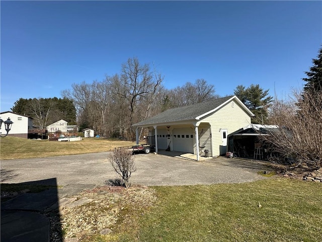 view of home's exterior with aphalt driveway, a lawn, an outbuilding, and a garage