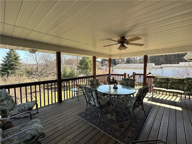 wooden deck with outdoor dining space, a water view, and ceiling fan