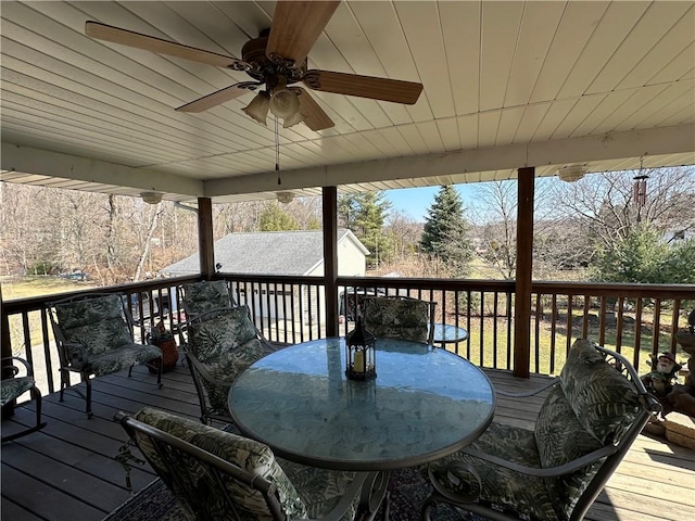 wooden deck featuring outdoor dining area and a ceiling fan