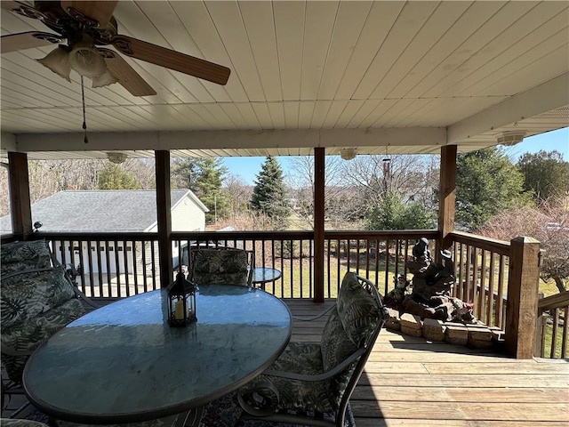 wooden deck featuring outdoor dining area and ceiling fan