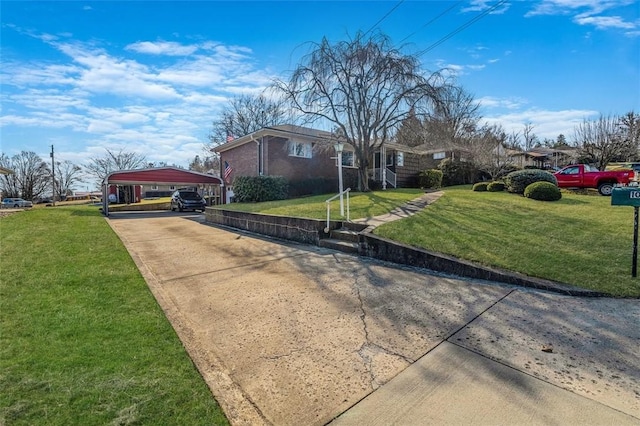 view of side of property with a lawn, a detached carport, concrete driveway, and brick siding