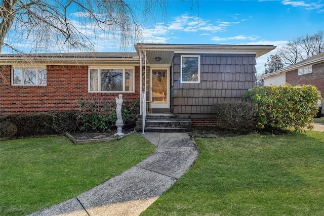 view of front facade featuring brick siding and a front yard