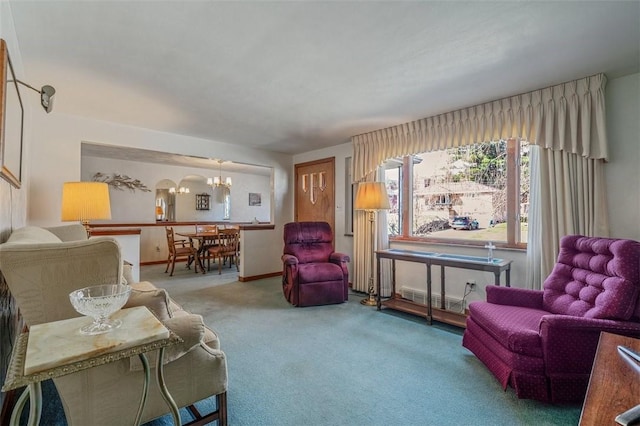 living area featuring a chandelier, baseboards, and carpet floors