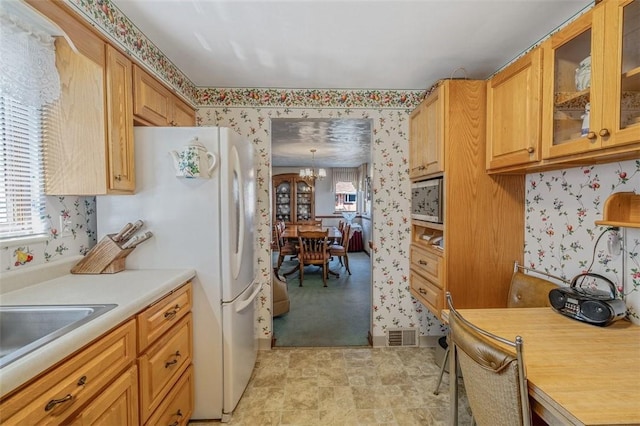 kitchen with visible vents, a healthy amount of sunlight, wallpapered walls, and light countertops