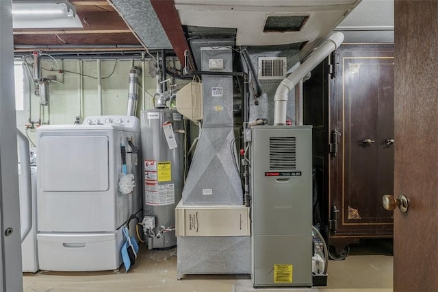 utility room featuring visible vents, water heater, and washer and clothes dryer