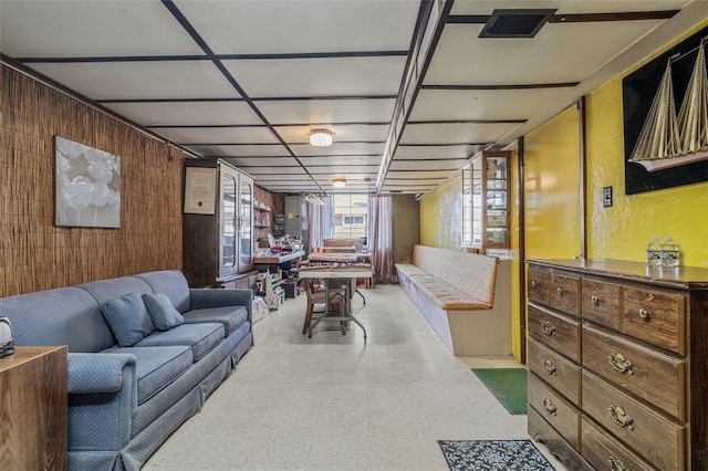 living room with tile patterned floors and wood walls