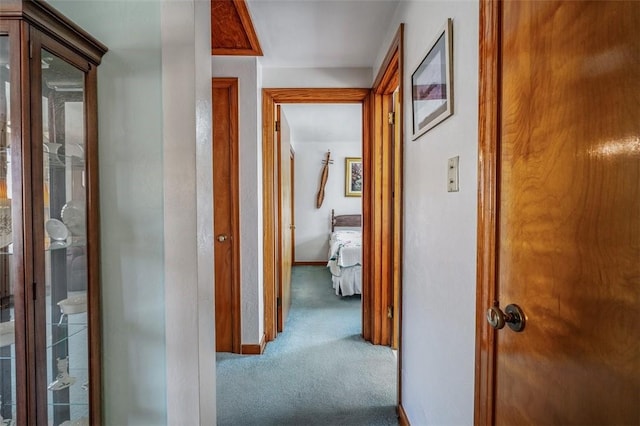 hallway featuring carpet flooring and baseboards