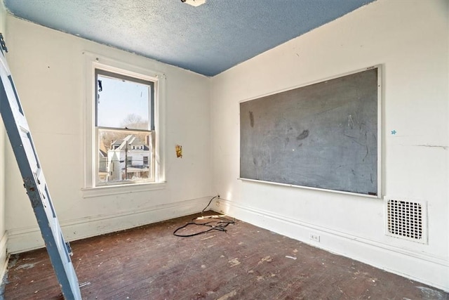 unfurnished room featuring visible vents and a textured ceiling