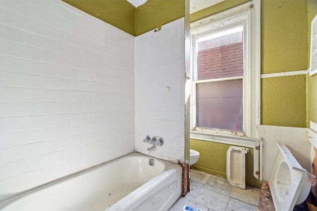 bathroom featuring toilet and a textured wall