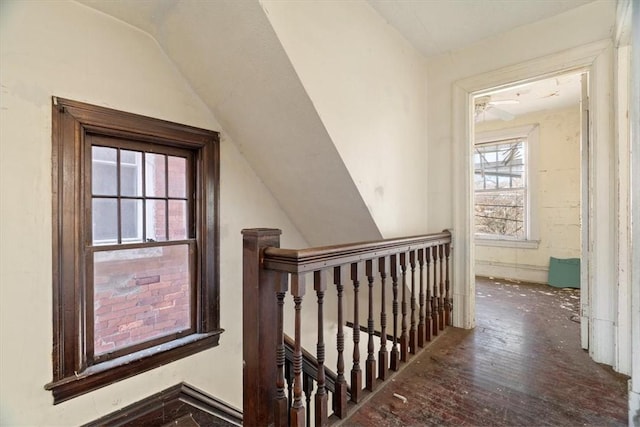 hall featuring vaulted ceiling and an upstairs landing