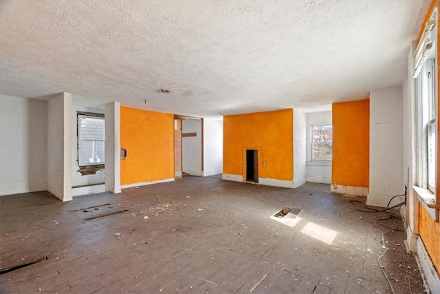 unfurnished living room featuring baseboards and a textured ceiling