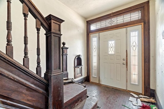 entrance foyer featuring a textured ceiling, stairs, and hardwood / wood-style flooring