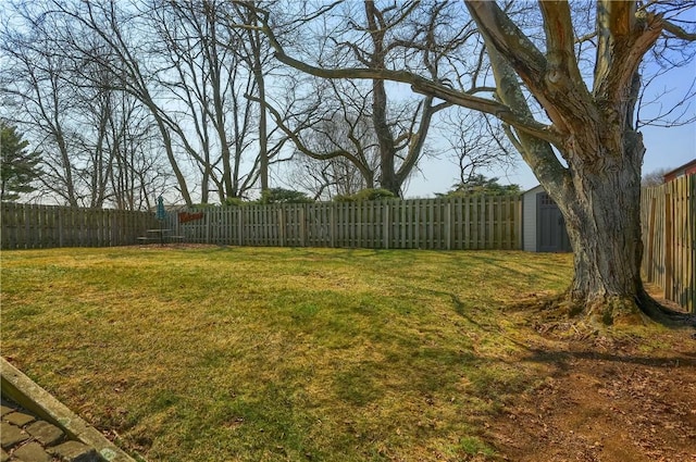 view of yard featuring an outbuilding, a storage shed, and a fenced backyard