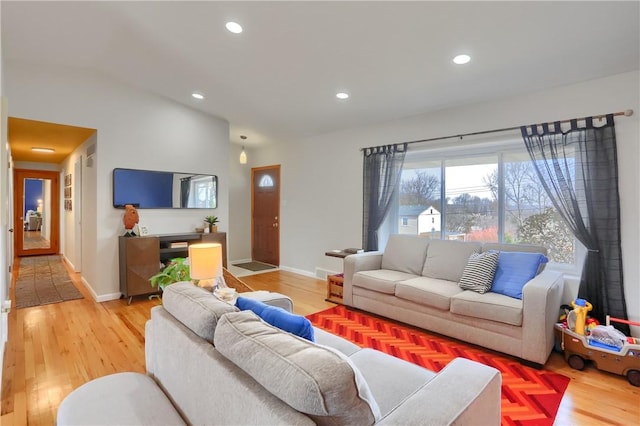 living area featuring lofted ceiling, recessed lighting, light wood-style floors, and baseboards