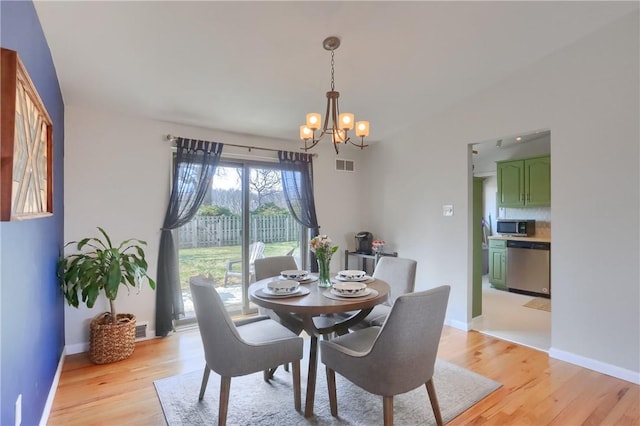 dining room with a chandelier, visible vents, baseboards, and light wood-style floors