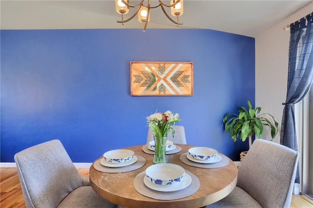 dining space featuring a notable chandelier, wood finished floors, and baseboards