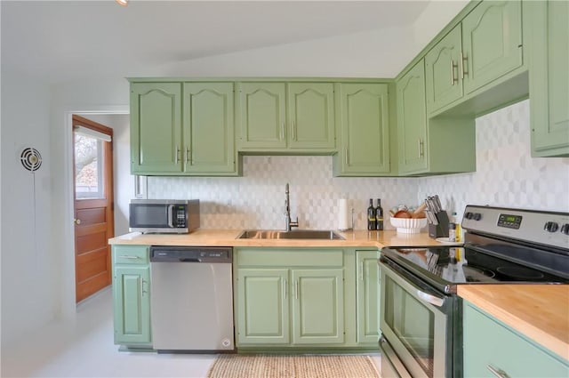 kitchen featuring appliances with stainless steel finishes, light countertops, green cabinets, and a sink