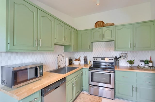 kitchen with tasteful backsplash, green cabinetry, appliances with stainless steel finishes, and a sink