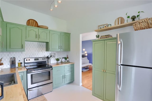 kitchen featuring open shelves, green cabinetry, and stainless steel appliances