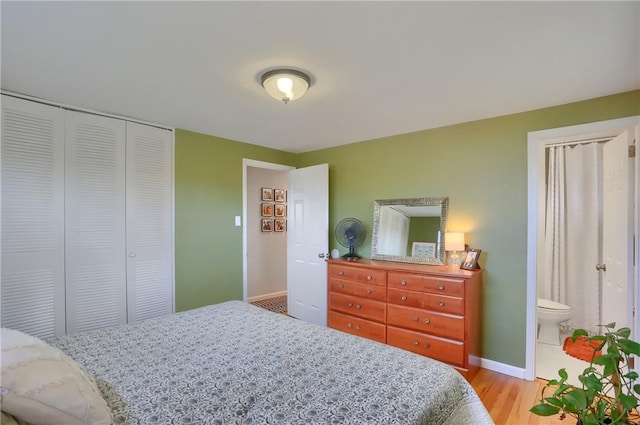 bedroom with light wood-style floors, baseboards, and a closet