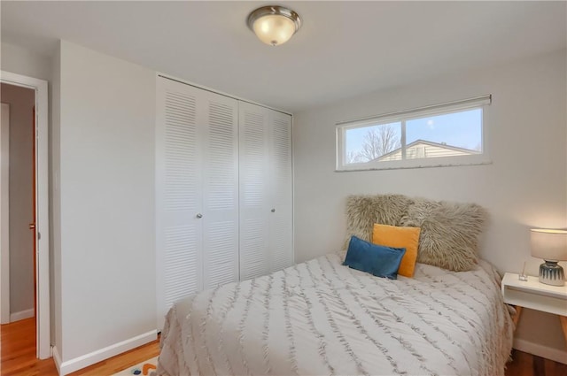 bedroom featuring a closet, baseboards, and wood finished floors