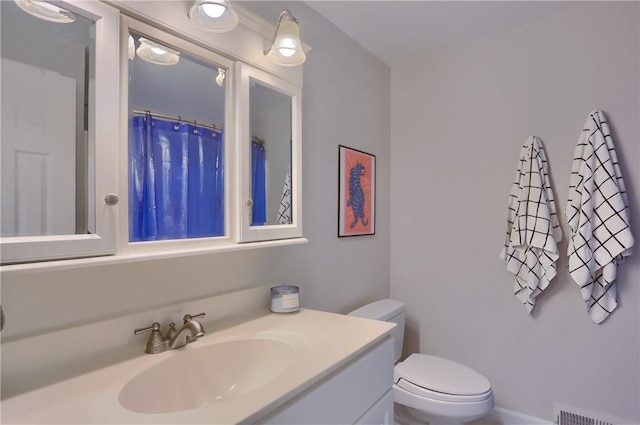 bathroom featuring visible vents, toilet, and vanity