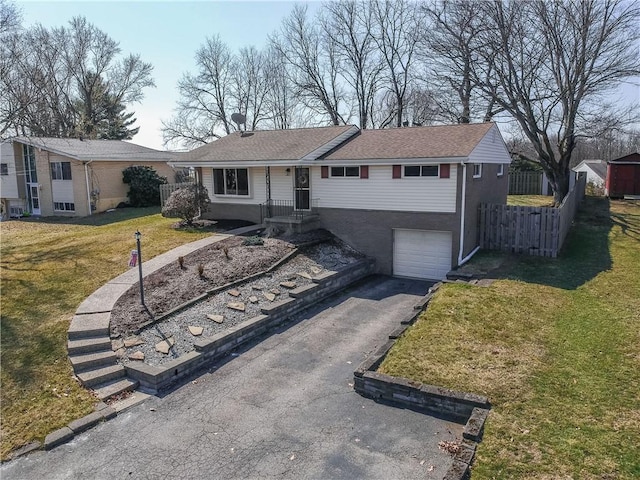 ranch-style house with a garage, a front yard, driveway, and fence