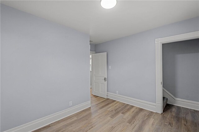 spare room featuring wood finished floors and baseboards