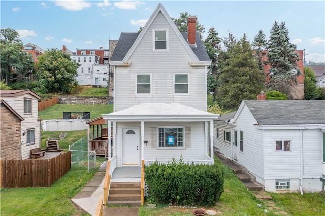 view of front facade with fence, cooling unit, covered porch, a front yard, and a chimney