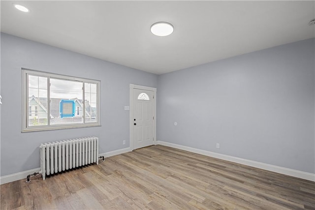 entryway featuring baseboards, radiator, and wood finished floors