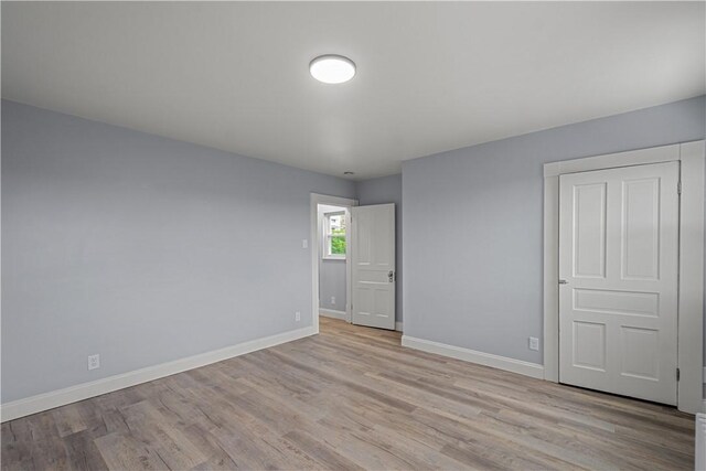 unfurnished room with wood finished floors and baseboards