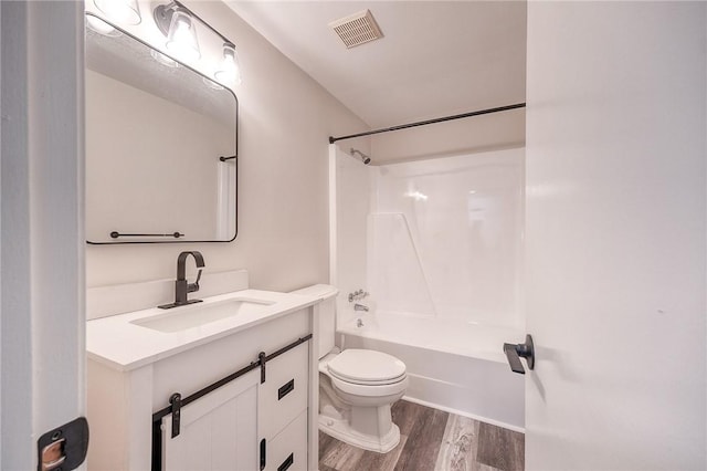 full bath featuring visible vents, toilet, shower / bathing tub combination, wood finished floors, and vanity