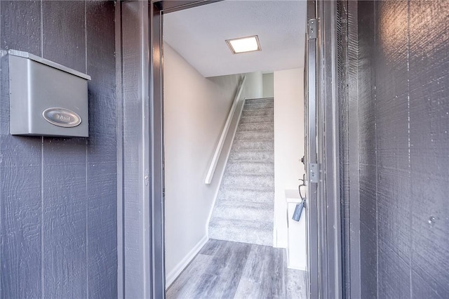 stairs featuring wood finished floors and baseboards