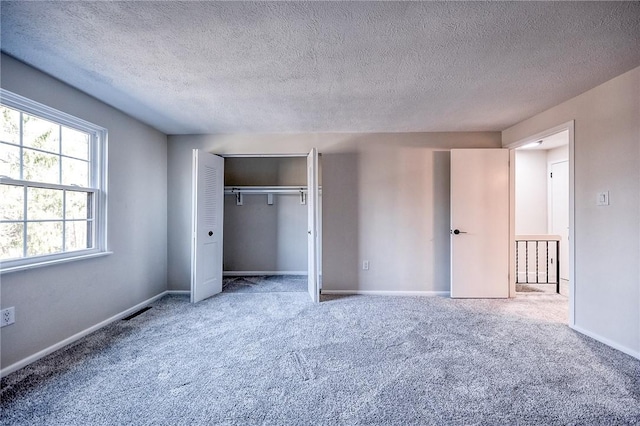 unfurnished bedroom with a closet, baseboards, and carpet flooring