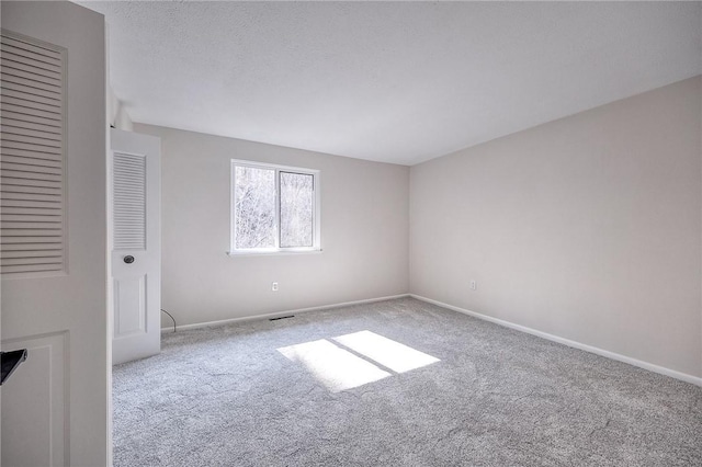 unfurnished bedroom with a textured ceiling, baseboards, and carpet