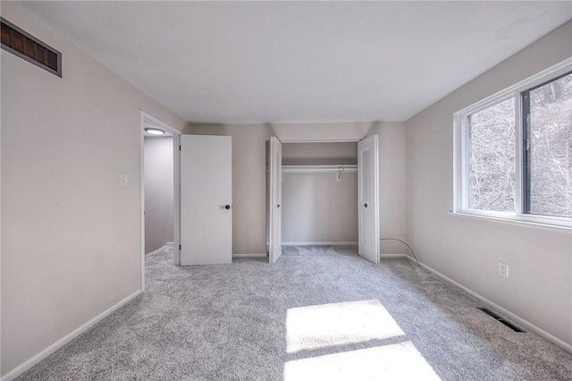 unfurnished bedroom with a closet, visible vents, baseboards, and carpet