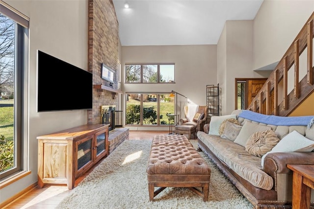 living area featuring a brick fireplace, wood finished floors, and high vaulted ceiling