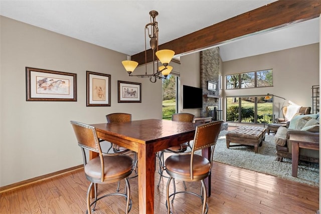 dining room with beamed ceiling, baseboards, an inviting chandelier, and wood-type flooring