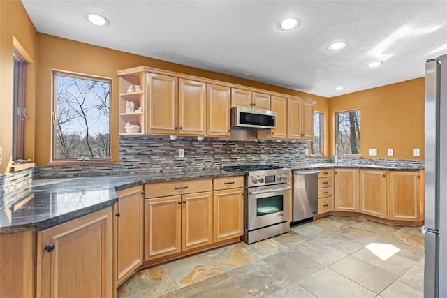 kitchen featuring dark stone counters, open shelves, recessed lighting, appliances with stainless steel finishes, and backsplash