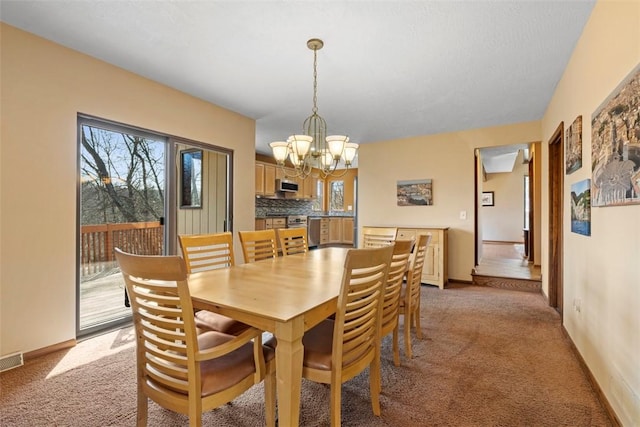 dining area featuring visible vents, baseboards, a chandelier, and light carpet