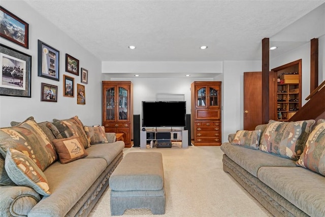 living area with recessed lighting, carpet, and a textured ceiling