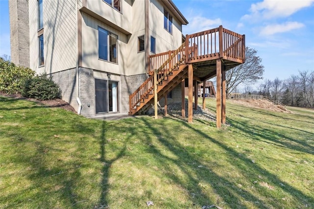 rear view of property with stairway, a lawn, and a wooden deck